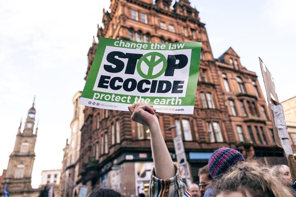 EU moves to criminalise 'ecocide' 1 A protestor holds a sign saying 'stop ecocide'