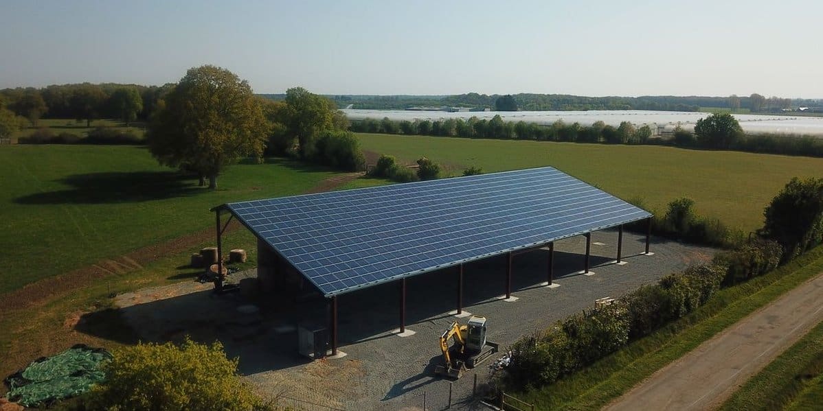 A farm in France with a shed covered in solar panels that supply clean, renewable energy.