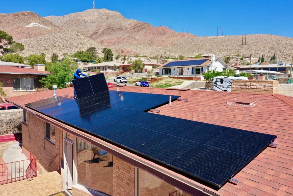 A man installing solar panels on a rooftop in El Paso