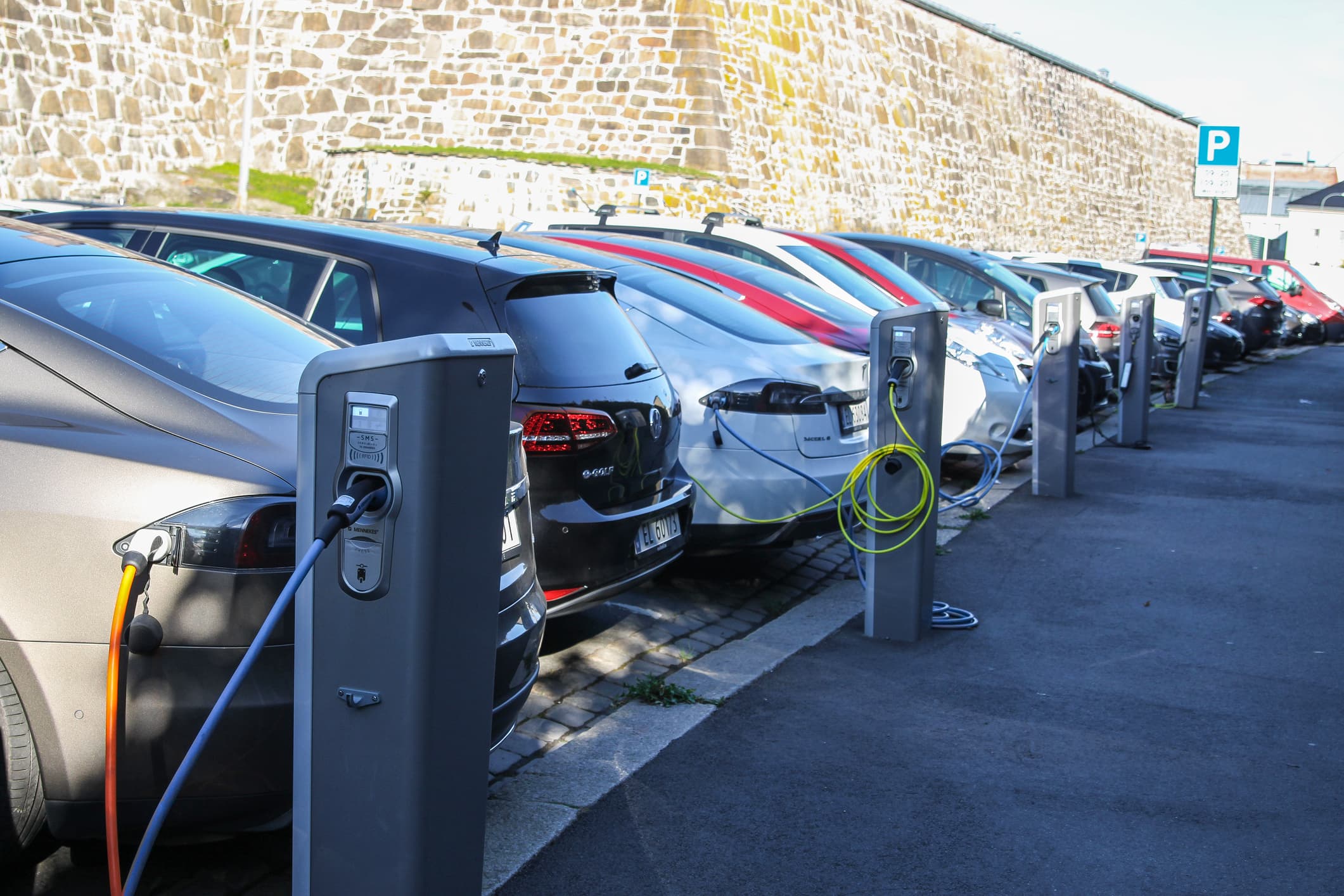 A row of electric vehicles charging their batteries.