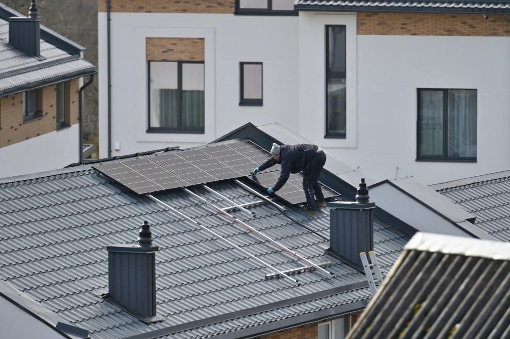 Free from Russia's grid, Lithuania advances towards 100% renewable power by 2030 1 A man installing solar panels on a rooftop in Vilnius, Lithuania. The country is a frontrunner in the transition to 100% renewable electricity.