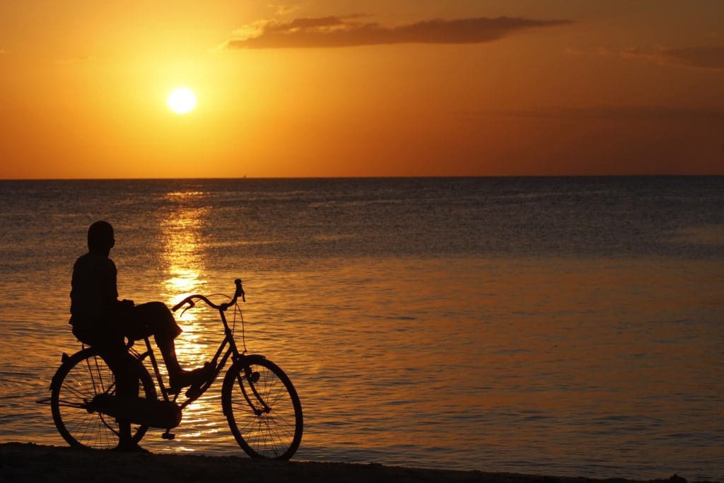 These African cities are speeding up the shift to bike-friendly streets 1 A photo of a boy watching the sunset while sitting on his bicycle in Tanzania.